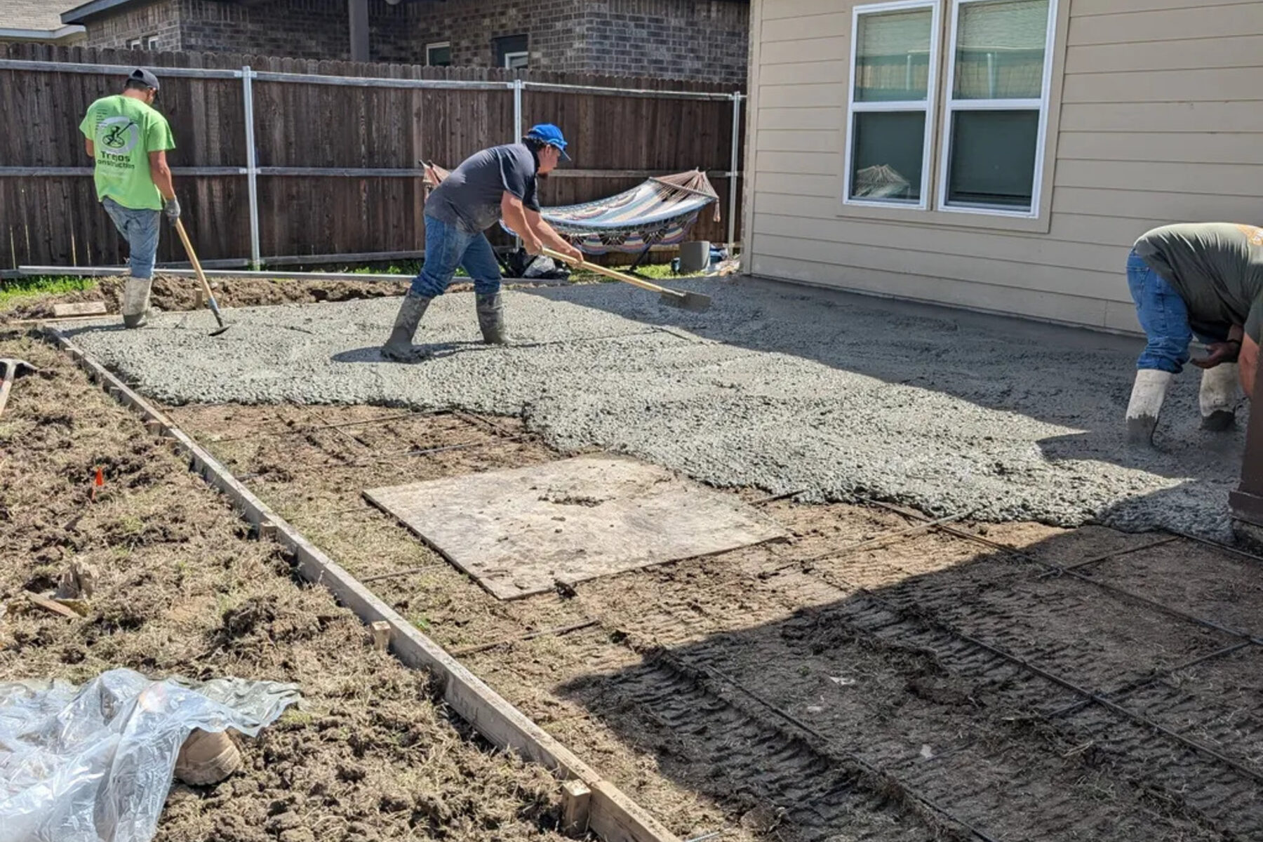 Crew forming and screeding a fresh concrete pour
